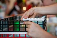 a person adding blocks to a building constructed using legos